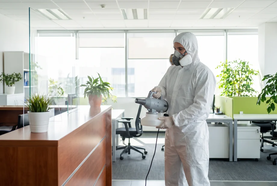 Técnico realizando sanitización profesional de oficina